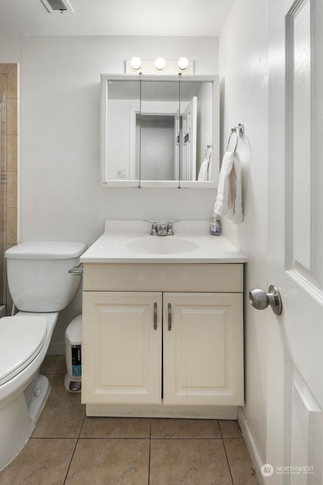 bathroom featuring vanity, tile patterned flooring, and toilet