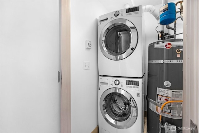 clothes washing area with laundry area, water heater, and stacked washing maching and dryer