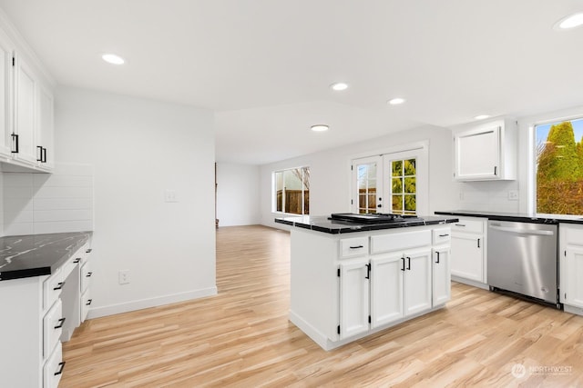 kitchen with stainless steel dishwasher, white cabinets, light hardwood / wood-style floors, and french doors