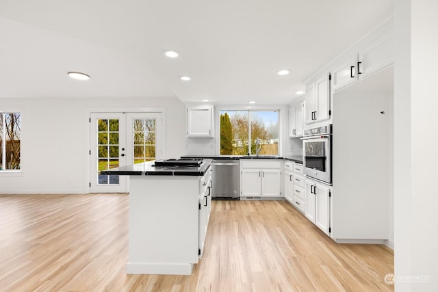 kitchen featuring sink, white cabinets, light hardwood / wood-style floors, stainless steel appliances, and french doors