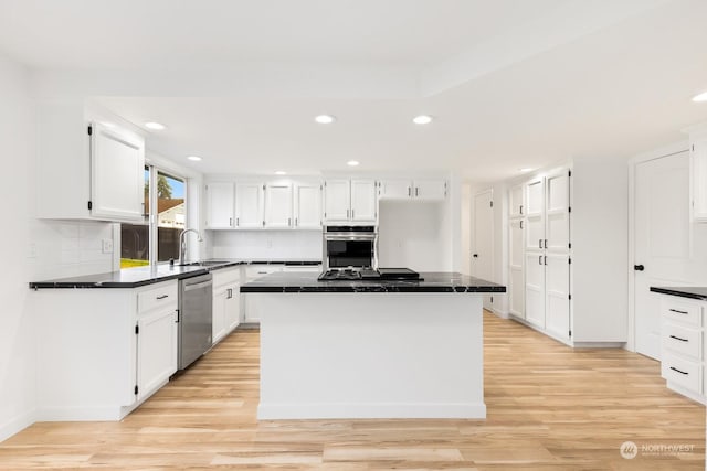 kitchen with a kitchen island, dishwasher, white cabinets, decorative backsplash, and light hardwood / wood-style floors