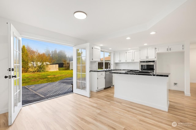 kitchen featuring white cabinetry, sink, stainless steel dishwasher, light wood-type flooring, and french doors