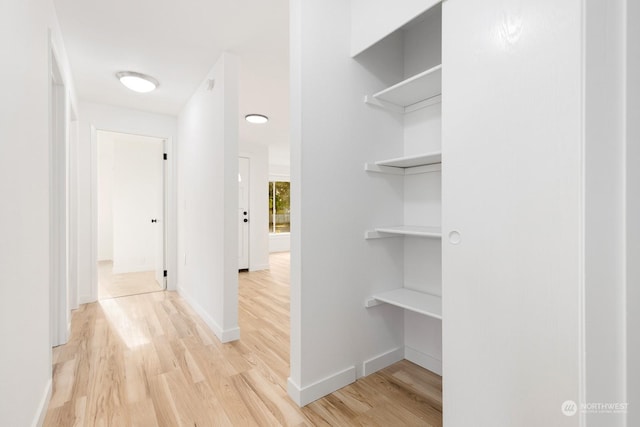 corridor with light hardwood / wood-style flooring