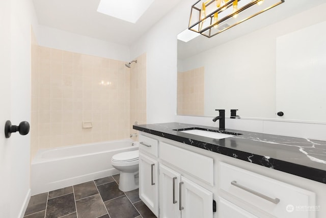 full bathroom featuring vanity, tiled shower / bath combo, a skylight, and toilet