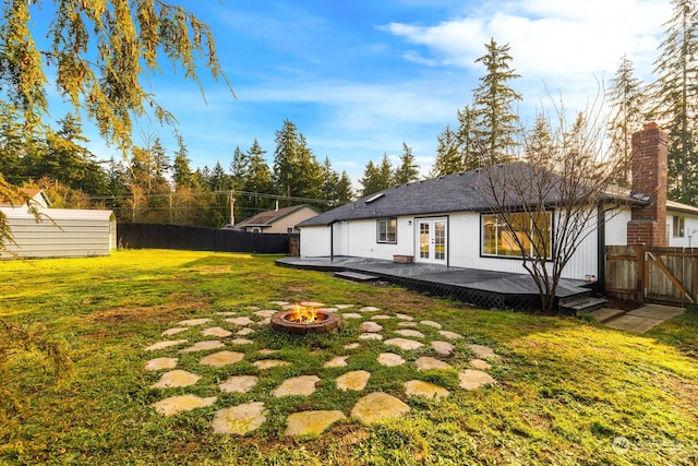 view of yard with a wooden deck and an outdoor fire pit