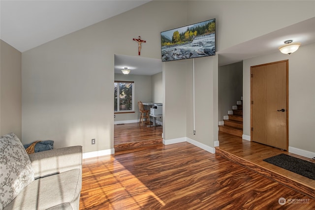 unfurnished living room with hardwood / wood-style floors and high vaulted ceiling