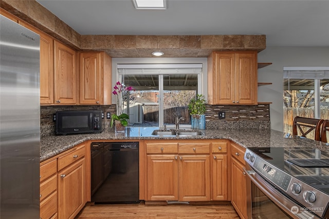 kitchen with sink, decorative backsplash, plenty of natural light, and black appliances