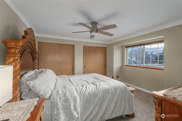 bedroom featuring crown molding, two closets, ceiling fan, and carpet flooring