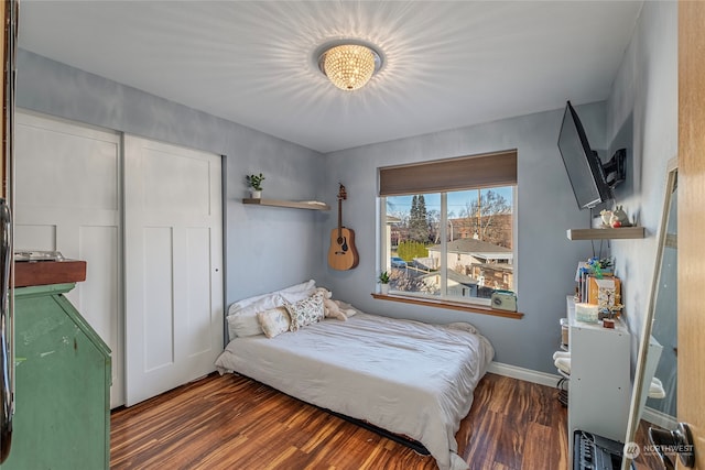 bedroom with dark hardwood / wood-style floors and a closet