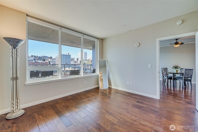 spare room featuring ceiling fan and dark wood-type flooring