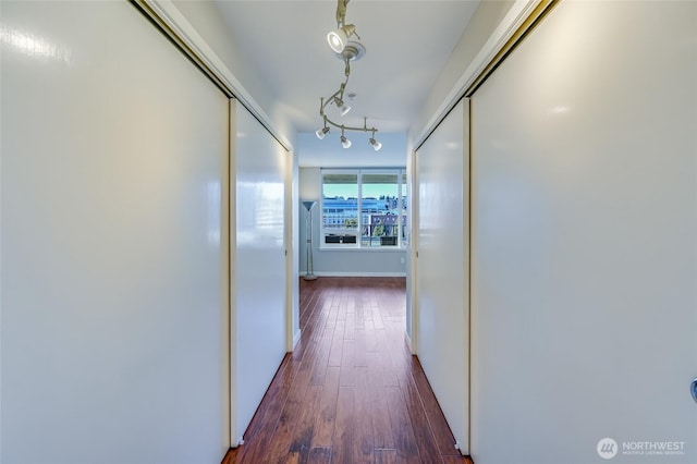 hall featuring track lighting and dark hardwood / wood-style flooring