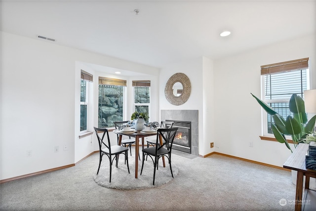 dining area with carpet flooring and a tile fireplace