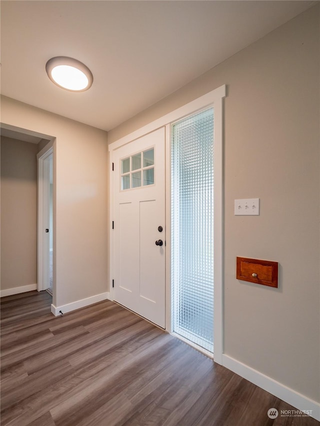 foyer with dark wood-style floors and baseboards