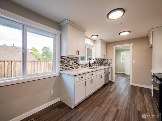 kitchen with appliances with stainless steel finishes, white cabinets, backsplash, and baseboards