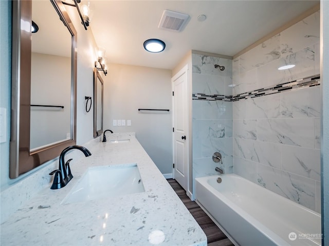 bathroom featuring vanity, hardwood / wood-style flooring, and tiled shower / bath