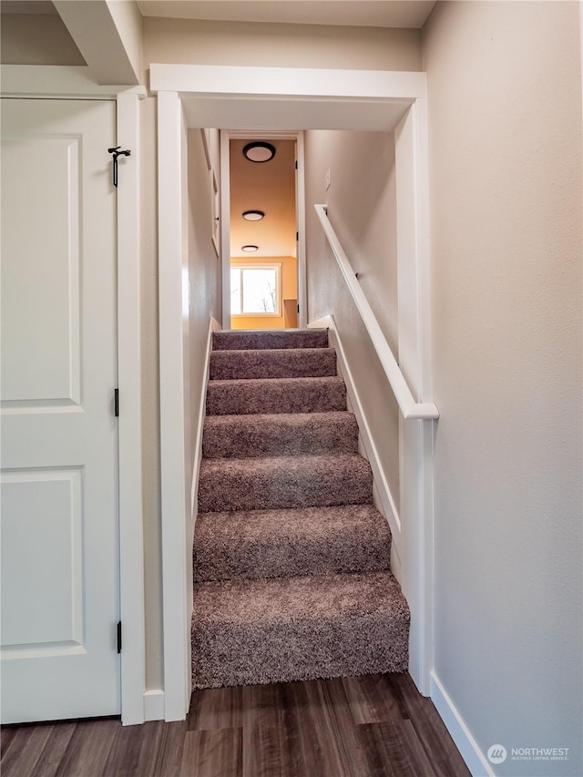 staircase with wood finished floors and baseboards