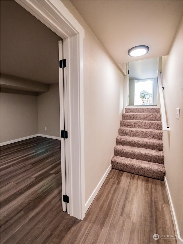 stairway with baseboards and wood finished floors