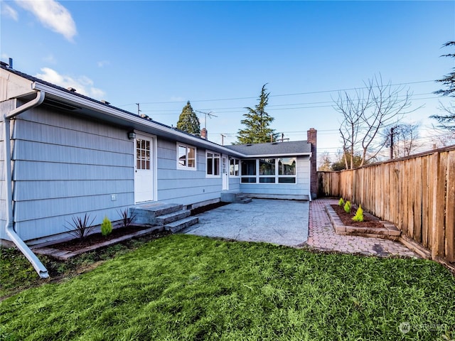 back of house featuring a patio and a lawn