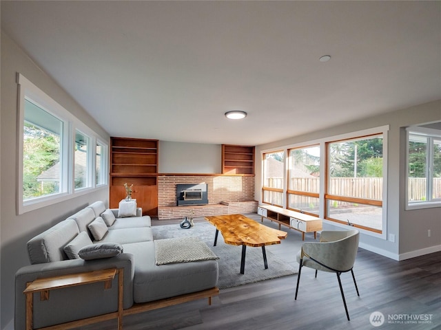 living room with dark wood-type flooring, a wealth of natural light, and baseboards