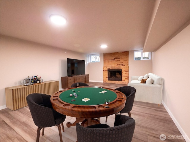 recreation room featuring light wood-style flooring, a fireplace, baseboards, and recessed lighting