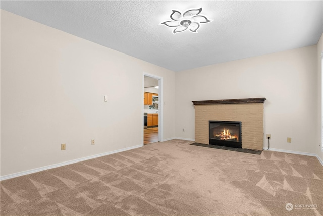 unfurnished living room with light colored carpet, a brick fireplace, and a textured ceiling