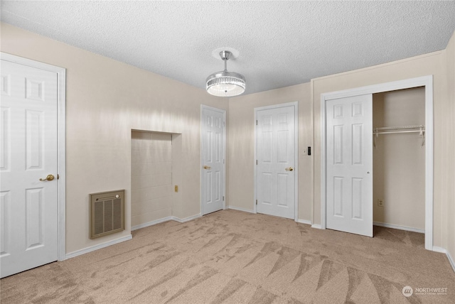 unfurnished bedroom featuring light colored carpet and a textured ceiling