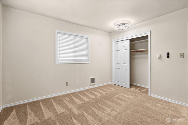 unfurnished bedroom with a closet and light carpet