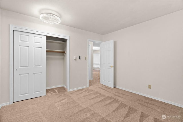 unfurnished bedroom with light carpet and a closet