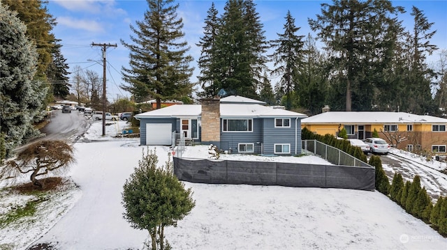 snow covered rear of property with a garage