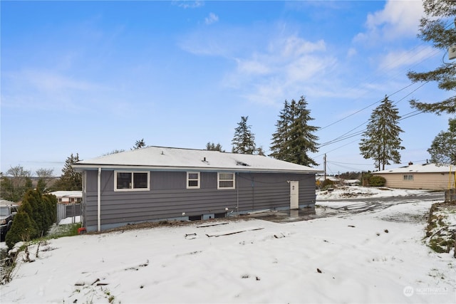 view of snow covered back of property