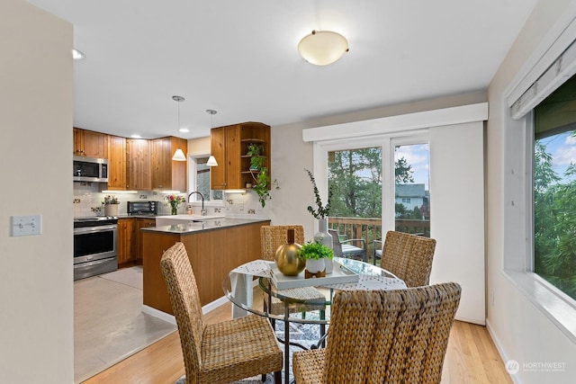 dining area with sink and light wood-type flooring