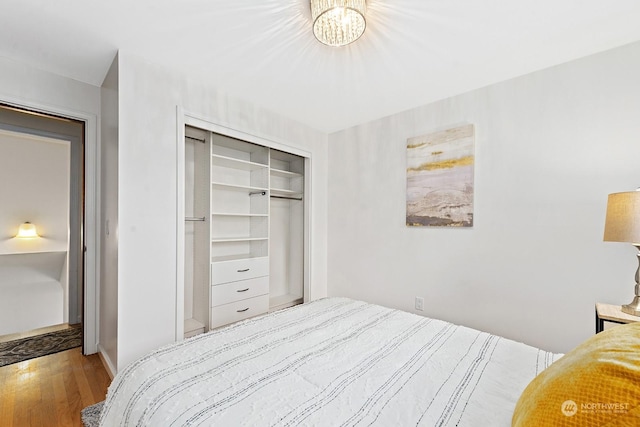 bedroom with a chandelier, light hardwood / wood-style floors, and a closet