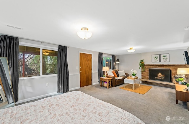 bedroom featuring a brick fireplace and carpet floors