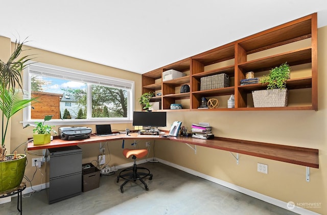 office with concrete flooring and built in desk