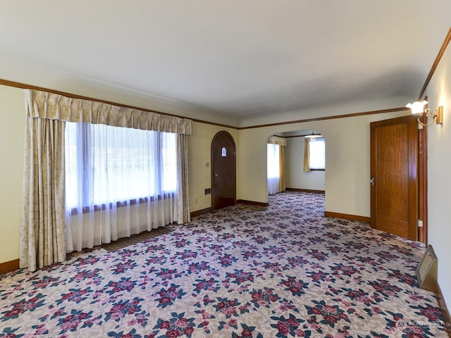 carpeted empty room featuring crown molding