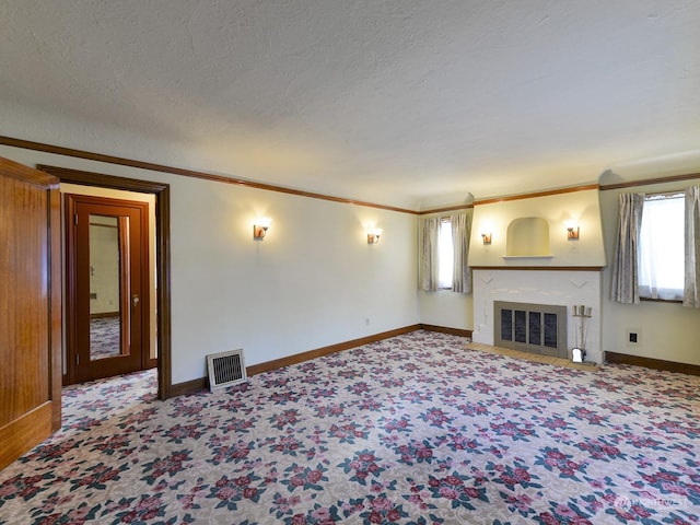 unfurnished living room with crown molding, carpet, and a textured ceiling