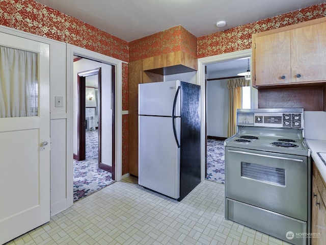 kitchen featuring stainless steel refrigerator, light brown cabinetry, and electric range oven