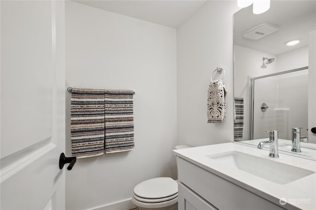 bathroom with vanity, toilet, and a shower with door