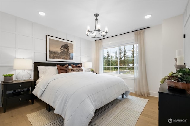 bedroom featuring a chandelier and light hardwood / wood-style flooring