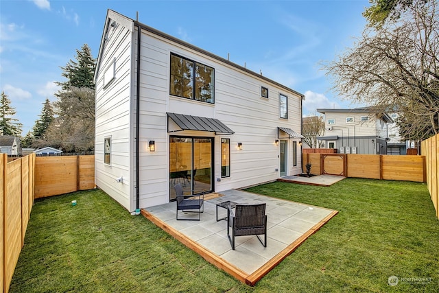 back of house with a patio area and a lawn