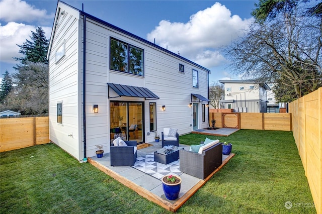 rear view of property featuring a patio, an outdoor living space with a fire pit, and a lawn