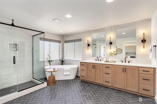 bathroom featuring shower with separate bathtub, tile walls, and vanity