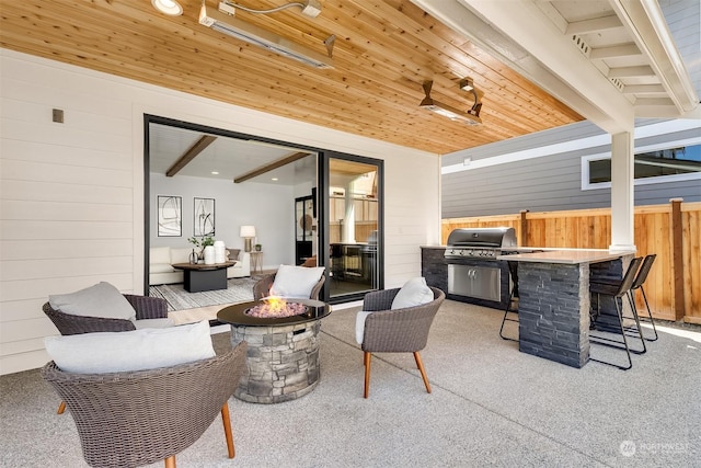 view of patio featuring a bar, area for grilling, and a fire pit