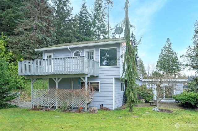 back of house with a wooden deck and a lawn