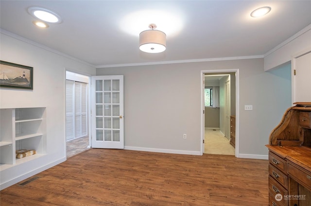 interior space with ornamental molding and hardwood / wood-style floors