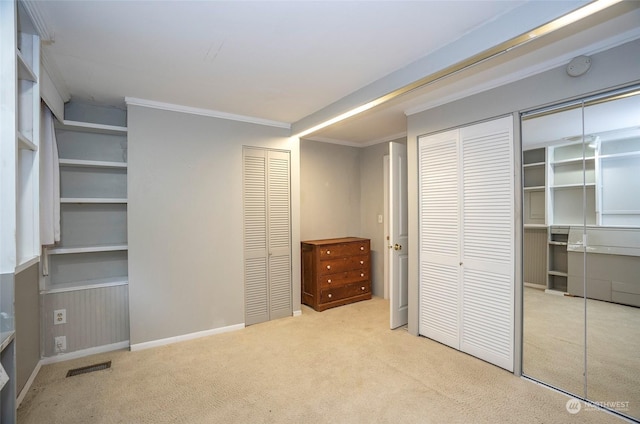 unfurnished bedroom with multiple closets, light colored carpet, and ornamental molding