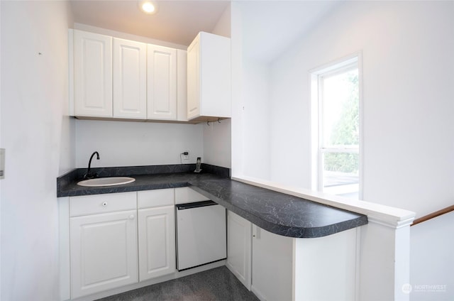 kitchen featuring sink, white cabinets, refrigerator, and kitchen peninsula