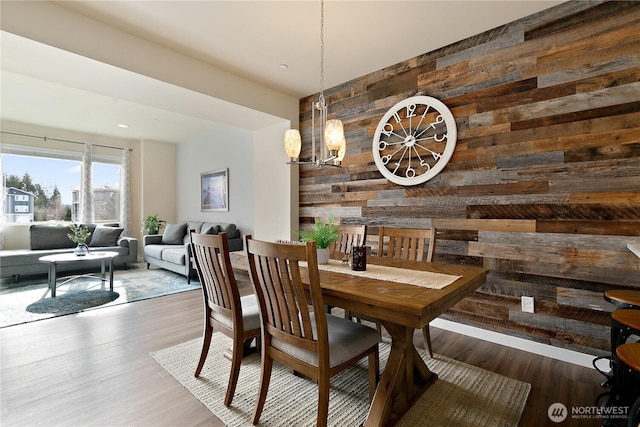 dining room with wooden walls and wood finished floors