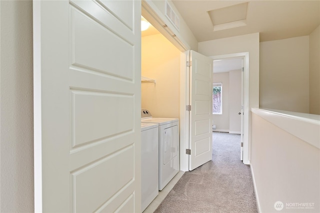 corridor featuring light carpet, visible vents, baseboards, independent washer and dryer, and attic access