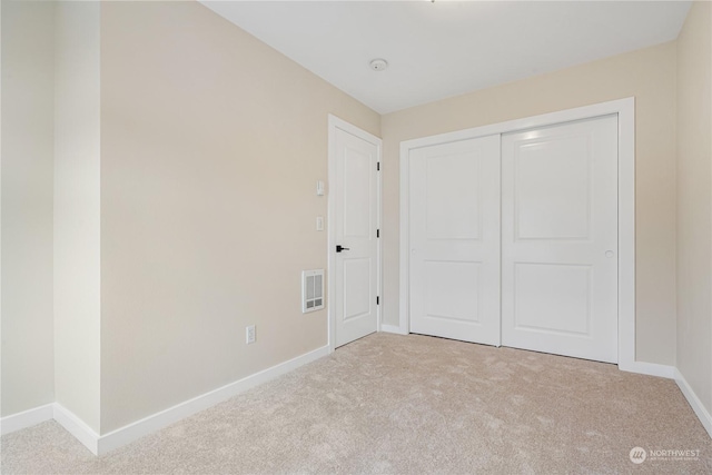 unfurnished bedroom with a closet and light carpet